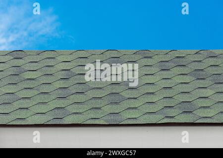 Green mosaic tile roof house structure abstract building home pattern design object blue sky background. Stock Photo