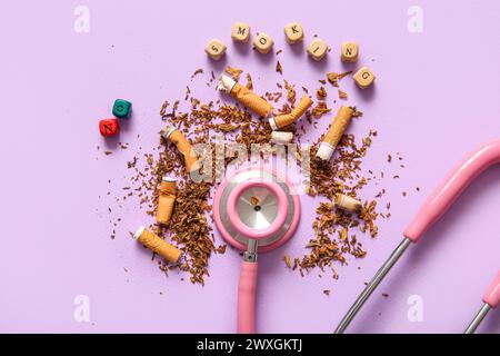 Composition with cigarette butts, stethoscope and wooden cubes with phrase NO SMOKING on lilac background. Stop smoking concept. Stock Photo