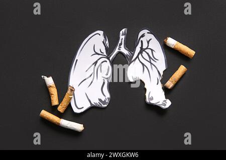 Paper lungs and cigarette butts on black background. Stop smoking concept. Stock Photo