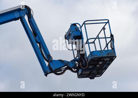 Extendable cherry picker with hydraulic arm and close up on cradle with safety rail Stock Photo