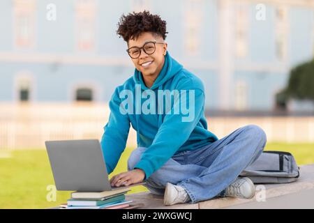 Happy student using laptop on university campus Stock Photo