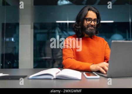 Man working on laptop in modern office Stock Photo