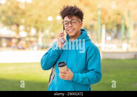 Happy student talking on phone with coffee Stock Photo