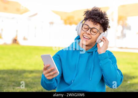 Student enjoying music on a sunny day Stock Photo