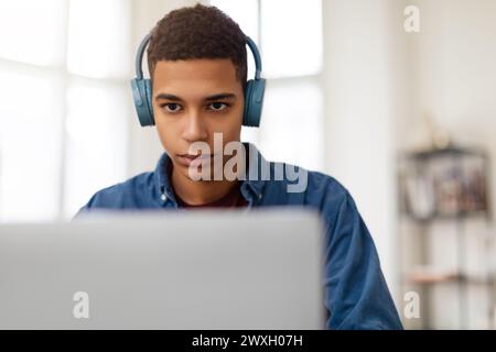 Young man with headphones using laptop Stock Photo