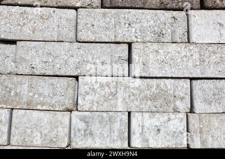 A closeup of a pile of stacked gray sand-lime bricks for building a house. Gray sand-lime brick Stock Photo