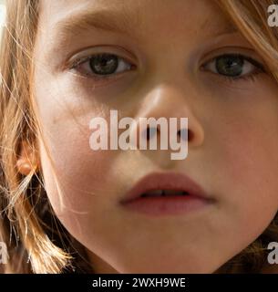 Portrait of a blond boy looking at the camera seen from very close Stock Photo