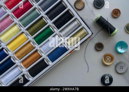 Spools of threads of different colors and different buttons Stock Photo