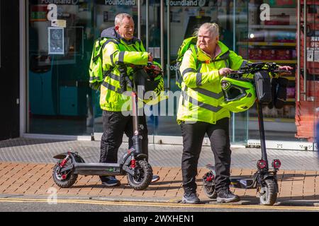 Elderly couple with prohibited I x6 electric scooters in Blackpool, Lancashire. His & hers Electric Scooters in Blackpool, UK 31 Mar 2024. UK Weather.  Credit; MediaWorldImages/AlamyLiveNews Stock Photo