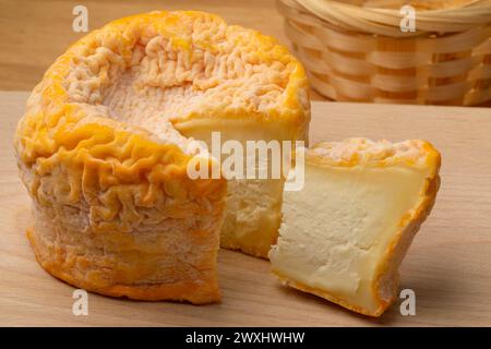Langres cheese refined with champagne and a piece on a cutting board  close up Stock Photo