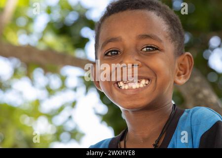 INDONESIA, ISLAND KRI - JANUARY 27, 2024: Papuan boy with shiny eyes shows his unhealthy teeth Stock Photo