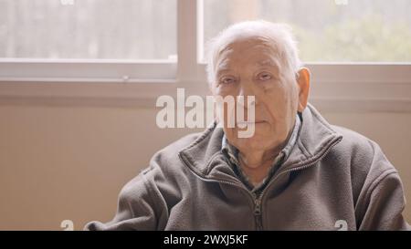 Aged man looking serious sitting on a geriatric Stock Photo