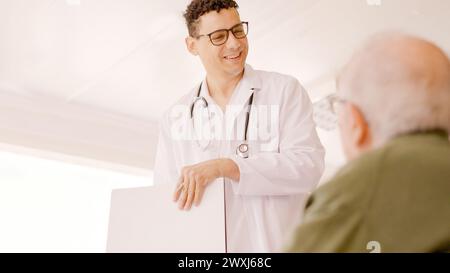 Doctor smiling kindly at an older man Stock Photo