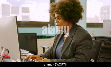 Concentrated woman working using computer in a coworking Stock Photo