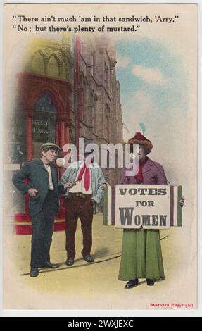 'There ain't much 'am in that sandwich, 'Arry.' 'No; but there's plenty of mustard': anti-suffragette postcard published by Bamforth & Co. Ltd. in the early 20th century. The colour image shows two working men standing on a street corner, passing comment on a 'suffragette' carrying a Votes For Women sandwich board. The 'suffragette', who appears to be a man dressed in a skirt, blouse and hat, is dressed in the colours of the Women's Social and Political Union (WSPU) Stock Photo
