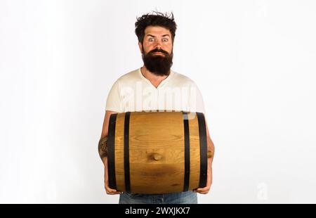 Surprised bearded man with oak barrel or cask of beer. Oktoberfest festival. Beer for pub or bar. Male brewer carrying wooden barrel with craft beer Stock Photo