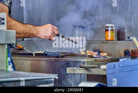 Professional Chef Grilling Steaks in an Industrial Kitchen Stock Photo