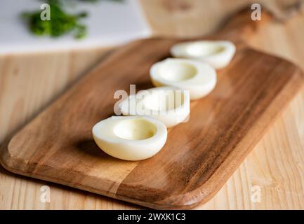 Empty hard boiled egg halves waiting to be filled with deviled egg mixture Stock Photo