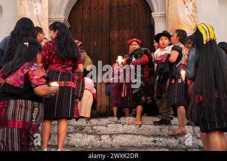 Chichicastenango, Guatemala. 30th Mar, 2024. Indigenous Mayan women wearing traditional huipiles hold candles on the steps of the Iglesia de Santo Tomás church before a vigil to mark Holy Saturday, March 30, 2024 in Chichicastenango, Guatemala. The Catholic Church and Mayan beliefs long ago mixed together in indigenous regions of Guatemala in a process called syncretism. Credit: Richard Ellis/Richard Ellis/Alamy Live News Stock Photo