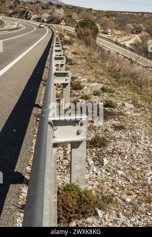 Metal safety guardrail on the edge of a conventional road Stock Photo