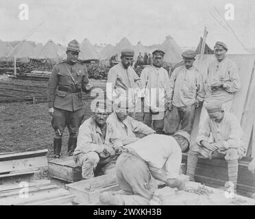 German prisoners of war working while an American officer watches ca. 1917-1918 Stock Photo