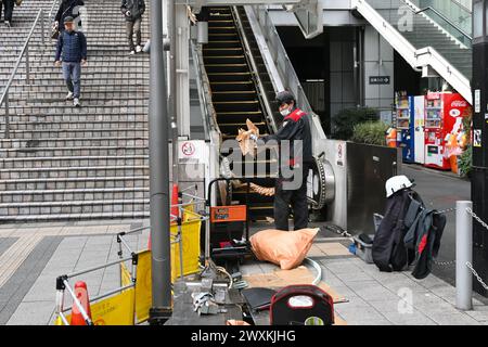 Worker performs maintenance and repairs on Escalator near Shinjuku station – Shinjuku, Tokyo, Japan – 29 February 2024 Stock Photo