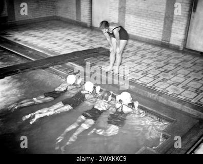 This photograph depicts a young woman affiliated with the National Youth Administration as she teaches a swimming lesson at the YWCA in Middletown, Connecticut ca. 1935-1942 Stock Photo