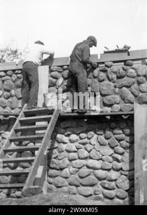 Two men working on stone house on the Sisseton-Wahpeton Oyate of the Lake Traverse Reservation, South Dakota ca. 1936-1942 Stock Photo