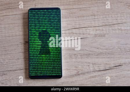 Smartphone with glowing binary code and keyhole on the screen. Copy space for text. Cyber security concept. Stock Photo