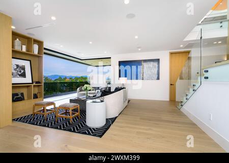 A modern living room with hardwood floors and a wooden staircase. Stock Photo