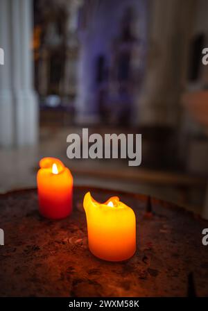 Two lit votive candles in a church with a blurred background Stock Photo