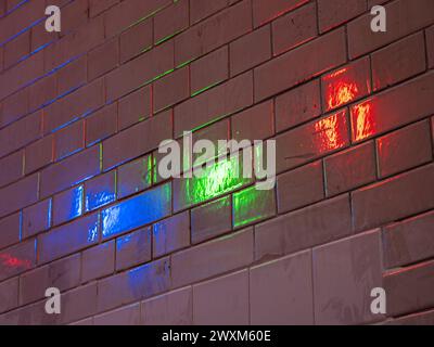 Reflection of colored lights - blue, green, red - on the wall tiles - background Stock Photo