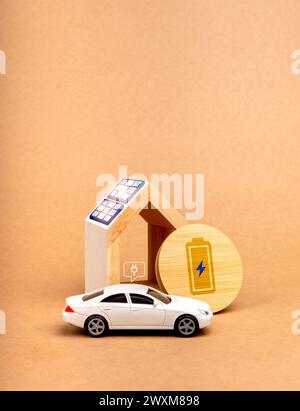 Sustainability at home concept. Battery power charging icon on round wood panel near solar panels being installed on home roof and white EV car with p Stock Photo