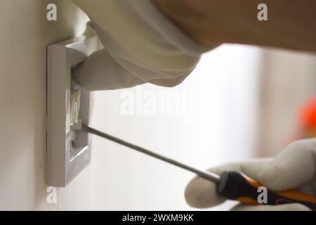 Installing an electric switch on the wall during the renovation of the apartment Stock Photo