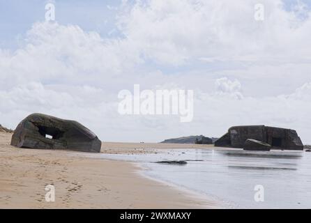 Erdeven, France - Mar 30, 2024: Bombed german Second World War bunkers on Erdeven beach, Brittany. Sunny spring day. Selective focus Stock Photo