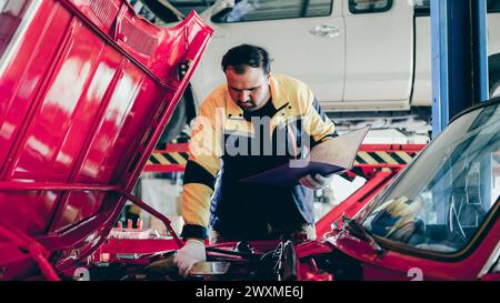 A male worker repairing a car in a garage Stock Photo