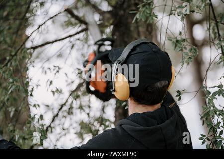A man cutting a tree with a circular saw Stock Photo