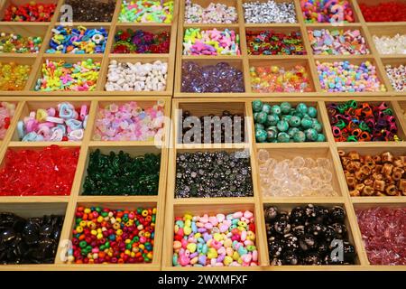 Variety of Colors and Shapes of Beads in Wooden Compartment Display Boxes for DIY Accessories Stock Photo