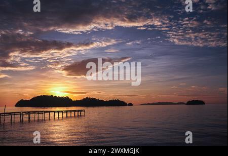 24.04.2009, Togian Islands, Sulawesi, Indonesia, Asia - Scenic sunset over a paradise palm tree beach at a tropical island in the Gulf of Tomini. Stock Photo