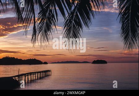 24.04.2009, Togian Islands, Sulawesi, Indonesia, Asia - Scenic sunset over a paradise palm tree beach at a tropical island in the Gulf of Tomini. Stock Photo