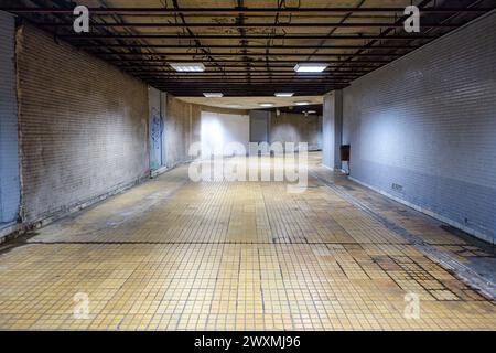 Empty abandoned underground corridor or tunnel with tiled floor and exposed ceiling structure in Bucharest, Romania Stock Photo