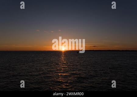 View of the sun going down over Dovercourt Bay from Landgaurd Point Felixstowe UK. February 2024 Stock Photo