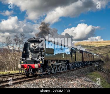 The image is of the Battle of Britain Class 4-6-2 #34067 Tangmere steam train after crossing the Dent Head viaduct in the Yorkshire Dales Stock Photo