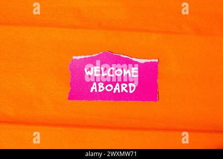 Welcome aboard words written on pink torn paper piece with orange background. Conceptual business symbol. Copy space. Stock Photo