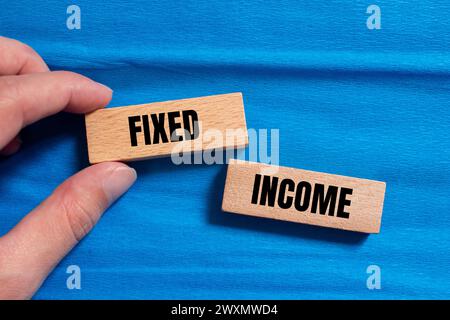 Fixed income words written on wooden blocks with blue background. Conceptual business symbol. Copy space. Stock Photo