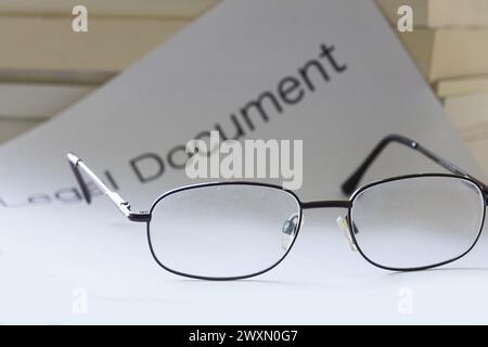 A close-up of eyeglasses resting on top of a legal document Stock Photo