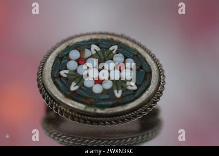 A glass trinket on pink surface, adorned with white pebbles Stock Photo