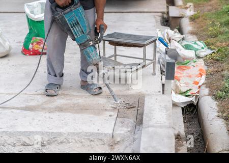 A male installer works with a electric hammer drill in Construction works. Stock Photo