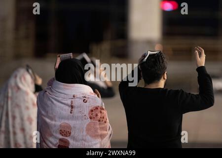 Tehran, Tehran, Iran. 1st Apr, 2024. Shiite worshipers place copies of the Quran on their heads during the holy Islamic month of Ramadan, in Tehran, Iran, Sunday, April 01, 2024. (Credit Image: © Sobhan Farajvan/Pacific Press via ZUMA Press Wire) EDITORIAL USAGE ONLY! Not for Commercial USAGE! Stock Photo