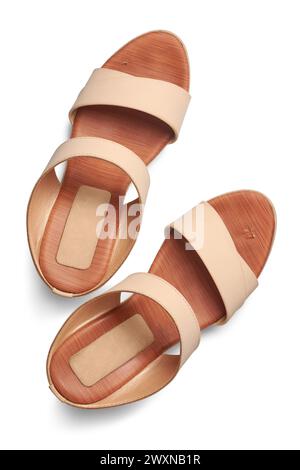 pair of used high heel sandals isolated white background, beige color simple female shoes with open or peep toe design taken straight above Stock Photo